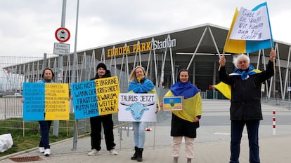 Pro-Ukrainian demonstrators hold signs, asking for Taurus cruise missiles to be delivered to Ukraine, outside football club SC Freiburg's Europa-Park Stadium as German Chancellor Olaf Scholz (not pictured) makes a visit in Freiburg, Germany, February 27, 2024.