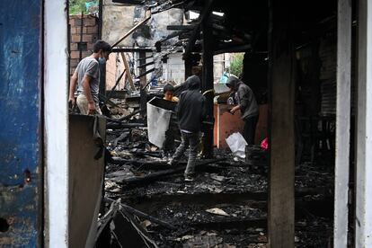 Niños y jóvenes recogen escombros la interior de una casa.