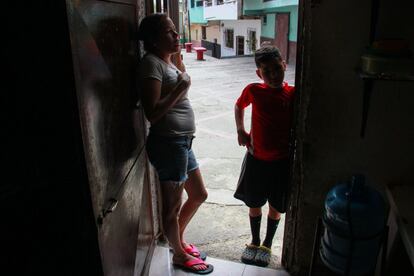 Carolina Castelin, en la puerta de su vivienda junto a uno de sus hijos. Ella y su hermana Seliandry, ambas desempleadas, han diseñado piezas para apoyar el aprendizaje de sus hijos, hasta el punto de que terminan haciéndoles los dibujos en los cuadernos. En Venezuela, en realidad, el virus es lo de menos. La pandemia encontró al país en emergencia humanitaria. Esta condición previa también ha hecho que sea un espejismo la vuelta a las clases en escuelas que no tienen agua para garantizar el lavado de manos y de las que los profesores han desertado en masa porque reciben menos de un dólar al mes de salario.