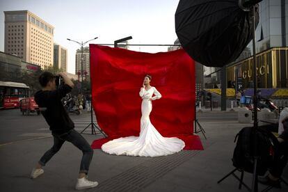 Una novia posa para un retrato en una concurrida calle de Xian, en la provincia de Shaanxi (China).