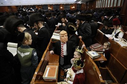 En este servicio religioso es costumbre que los fieles, sobre todo los niños, vayan a la sinagoga disfrazados. En la imagen, un niño judío ultraortodoxo disfrazado como el presidente de Estados Unidos, Donald Trump (centro), entre hombres que leen el 'Libro de Esthe'r, el 1 de marzo, en Jerusalén.