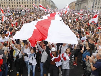 Los manifestantes ondean la bandera histórica de Bielorrusia, durante la manifestación de esta tarde. 