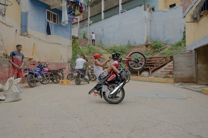 Gabriel Bastidas practices motorcycle tricks in the alleys of El Valle, Caracas.