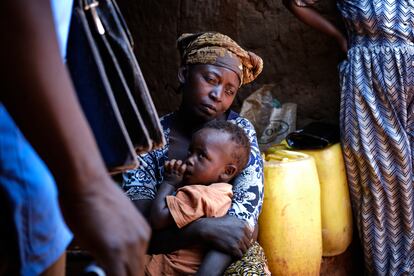 Una mujer sostiene a su hijo en brazos tras recibir la vacuna contra la poliomielitis salvaje, administrada por equipos de Unicef.