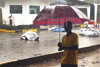 Un hombre pasa junto a varios cadáveres en una calle de la capital liberiana, Monrovia.