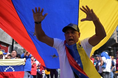 Un partidario de la oposición de Venezuela bajo una bandera venezolana.