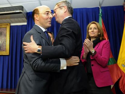 Gallardón (derecha) abraza a Carlos Urquijo en presencia de la presidenta del Parlamento vasco, Arantza Quiroga, ayer en Vitoria.
