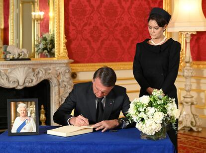 Jair Bolsonaro firmaba el domingo en el libro de condolencias de Isabel II, en Londres. Junto a él, su esposa, Michelle.