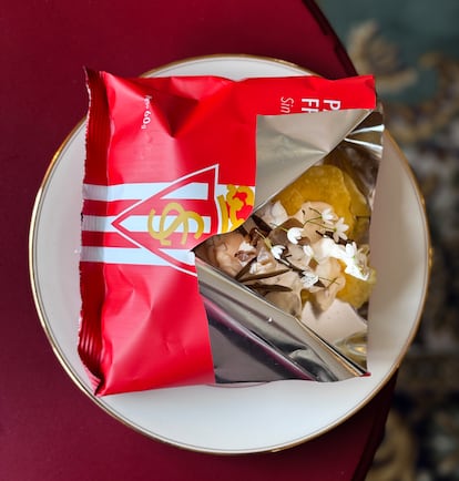 Patatas fritas aliñadas con requesón asturiano, limón y aceituna presentadas en bolsa personalizada con el escudo y los colores del Sporting de Gijón