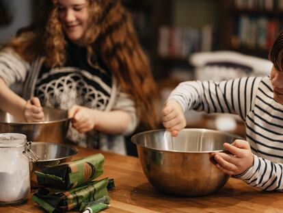 Un niño y una niña cocinan en su casa.