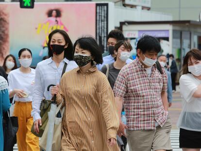 Un grupo de personas con mascarilla para protegerse de la covid caminan este martes por una calle de Tokio ç