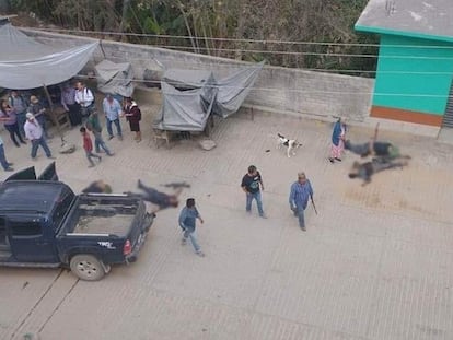 Personas miran los cuerpos de al menos cuatro hombres en una calle de Santiago Amoltepec, Oaxaca, este martes.