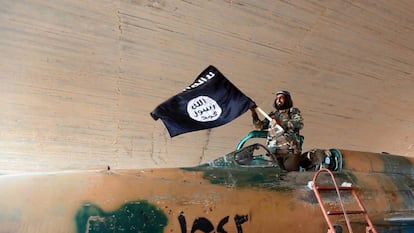 Un combatiente del ISIS ondea su bandera en Raqa (Siria), en 2015.
 