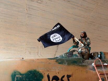 Un combatiente del ISIS ondea su bandera en Raqa (Siria), en 2015.
 