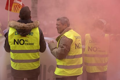 Dos trabajadores de Danone envueltos por el humo de las bengalas.