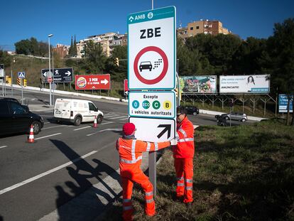 Operarios colocando señales indicativas de la Zona de Bajas Emisiones de Barcelona en 2019, antes de que entrara en vigor.