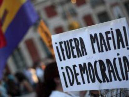 Detalle de una pancarta durante la manifestación que varios centenares de personas han llevado a cabo hoy en la capital, bajo el lema "Fuera mafia, hola democracia", convocados por el movimiento 15M,  para denunciar que políticos y banqueros, a los que consideran "la élite corrupta", son responsables de la actual situación de crisis.