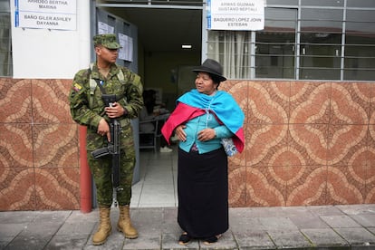Una ciudadana junto a un soldado que custodia un colegio electoral durante la segunda vuelta de las elecciones presidenciales en Quito, Ecuador.