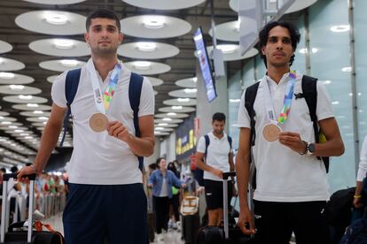 Los medallistas Asier Martínez (110m vallas) y Mohamed Katir (1.500m) llegan al aeropuerto de Barajas, este jueves.