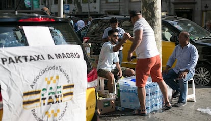 Miembros de la asociacion Paktaxi reparten bebidas gratuitamente durante las protestas de los taxistas en Barcelona.