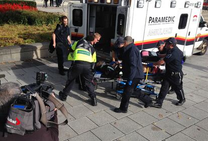 Policías y sanitarios trasladan hacia una ambulancia al soldado herido en el tiroteo ocurrido en el centro de Ottawa.