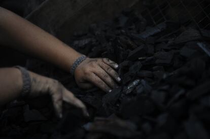 Un miembro de la familia Yáñez manipula las ascuas del carbón. El humo que genera daña los pulmones de los trabajadores causando enfermedades como neumonitis, la inflamación del tejido de ese órgano.