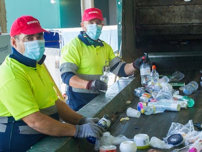 Dos trabajadores de la ONG Envera separan residuos en el aeropuerto de Málaga.