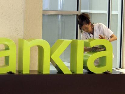 Una operaria limpia el logo de Bankia. EFE/Archivo