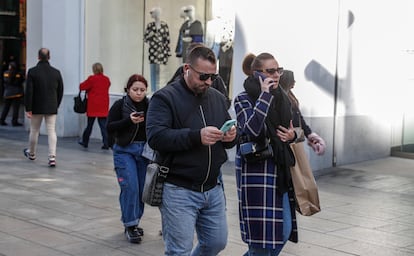 Usuarios de telefonía móvil en la Gran Vía de Madrid.