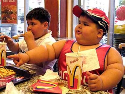 Un niño ruso de cuatro años y 56 kilos junto a otro niño obeso en un establecimiento de comida rápida en Tbilisi (Georgia).