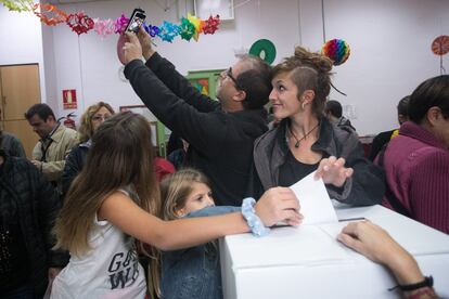 Una familia se hace 'selfie' mientras votan en una de las urnas de la escuela Proa en Barcelona.