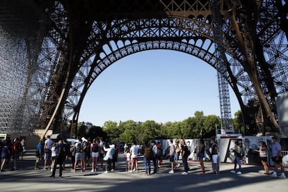 Los primeros visitantes de la Torre Eiffel, con calzado cómodo y muchas ganas, sudaron la gota gorda este jueves para subir las empinadas escaleras y admirar París desde el monumento más famoso de la ciudad, que reabrió sus puertas después de tres meses. En la imagen, la gente hace cola para subir a la Torre Eiffel, en París.