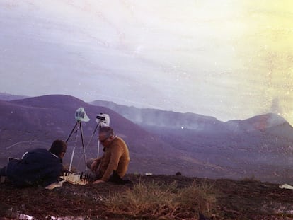 Dos hombres con cámaras sobre trípodes juegan al ajedrez tras la erupción del volcán Teneguía en la isla de La Palma en 1971.
