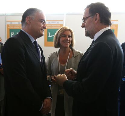 El presidente del Gobierno, Mariano Rajoy (d), conversa con el eruodiputado del partido Esteban González Pons, ante la presencia de la secretaria general del PP, María Dolores de Copedal.