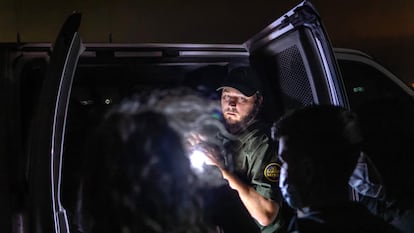 Un agente de la Patrulla Fronteriza inspecciona un vehículo con menores migrantes el 9 de diciembre de 2021 en Yuma (Arizona).