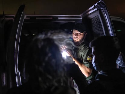Un agente de la Patrulla Fronteriza inspecciona un vehículo con menores migrantes el 9 de diciembre de 2021 en Yuma (Arizona).