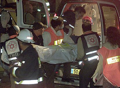 Un equipo de emergencia introduce en una ambulancia el cadáver de una víctima del atentado suicida de Netania.