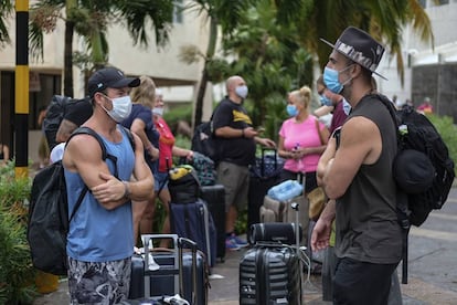 Los turistas esperan el transporte para regresar a sus hoteles después de dormir en un refugio.