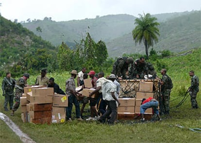 <i>Marines</i> estadounidenses y residentes locales descargan ayuda humanitaria en Mapou, 50 kilómetros al sureste de Puerto Príncipe (Haití).