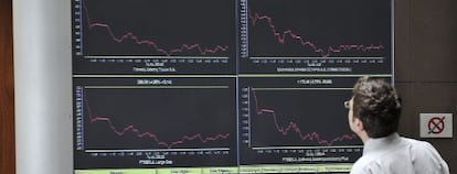 Un hombre observa unos gr&aacute;ficos en el panel de la Bolsa de Atenas en la capital griega. 