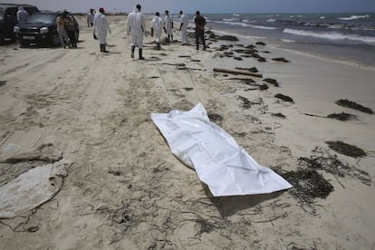 Varias personas recogen los cuerpos sin vida de inmigrantes que han aparecido en una playa en Zuwarah al oeste de Trípoli.