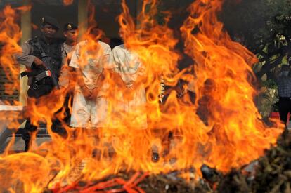 La policía indonesa quema una pila de marihuana incautada ante los dos sospechosos, en Banda Aceh (Indonesia). Un total de 800 kg de marihuana valorados en 180.000 dólares fueron destruidos.