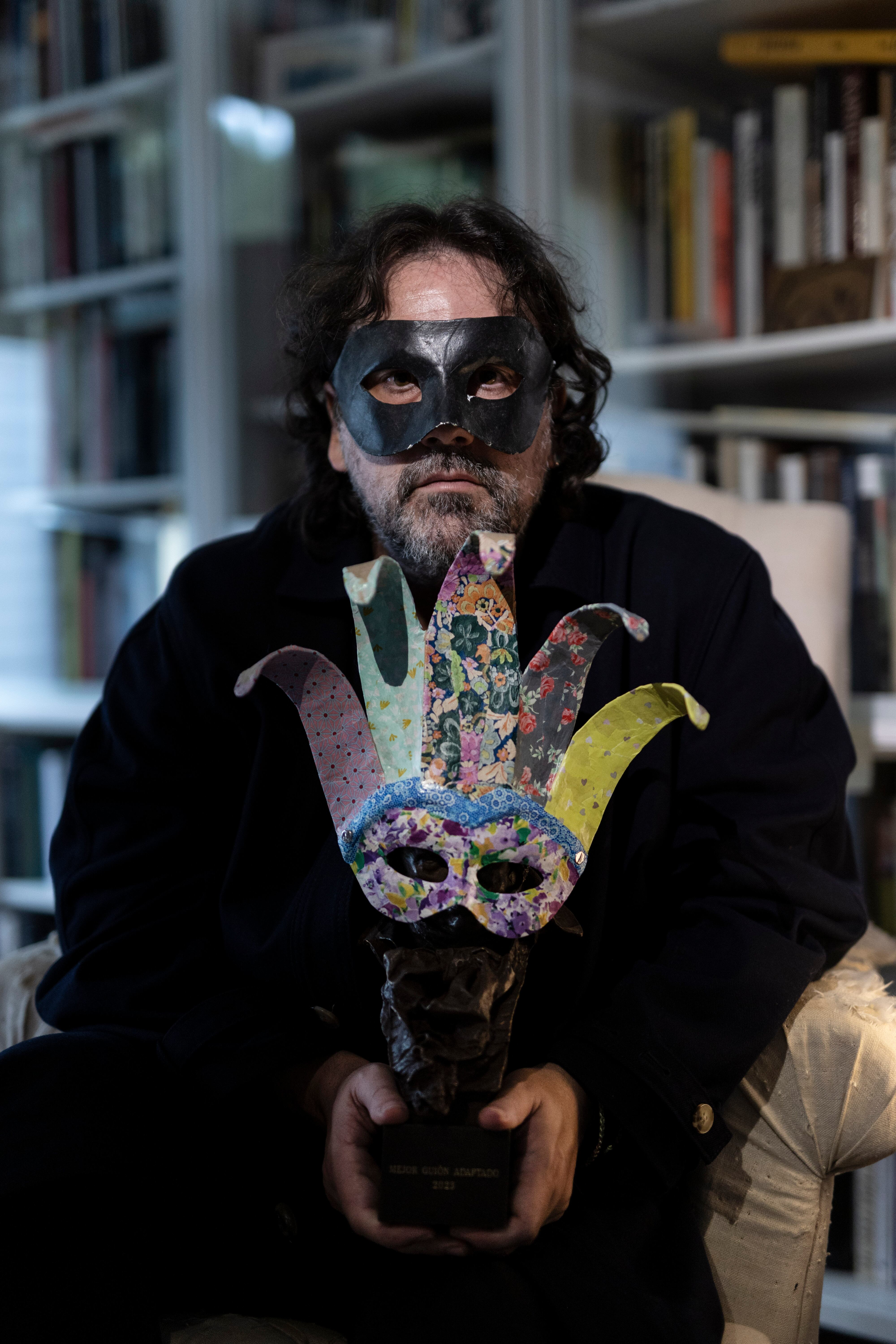 Isaki Lacuesta, en un sillón en su estudio con el premio Goya a mejor guion adornado con una máscara fabricada por su hija Luna.