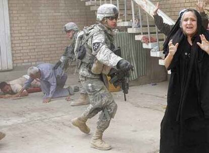 Una iraquí grita a unos soldados norteamericanos que se disponen a detener a su hijo y su marido en Baquba.
