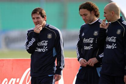 Leo Messi conversa con sus compañeros Gabriel Milito y Esteban Cambiasso.