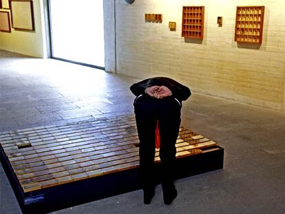 Una visitante observa las cajitas con objetos de la acción <i>Cadaverina 76,</i> de Barceló.