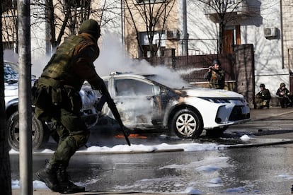 Un coche de policía arde delante de un cuartel en Kiev. Han apagado las llamas bomberos y militares del acuartelamiento.