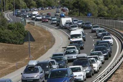 Un gran número de vehículos circulan lentamente en los dos carriles en sentido sur de la AP-7, la autopista del Mediterráneo, a su paso por la localidad de Altafulla (Tarragona).