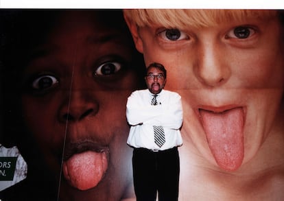 El fotógrafo italiano Oliviero Toscani posando frente a una fotografía suya para la campaña publicitaria de Benetton, en Roma, en los años 90.