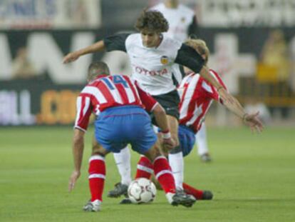 Aimar intenta regatear a varios jugadores del Atlético de Madrid.